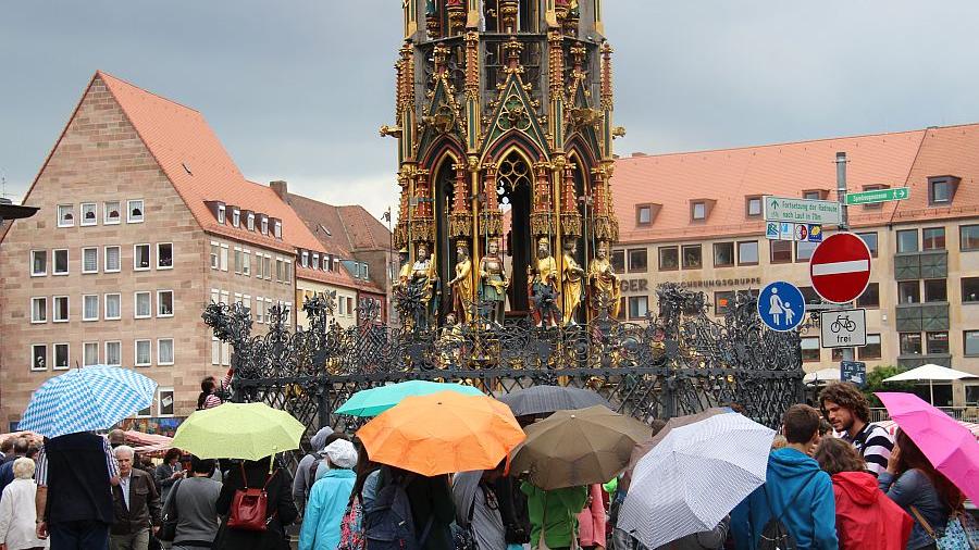 Ein Muss für jeden Touristen und Einheimischen. Drehen am Glücksring beim Schönen Brunnen auf dem Hauptmarkt in Nürnberg.