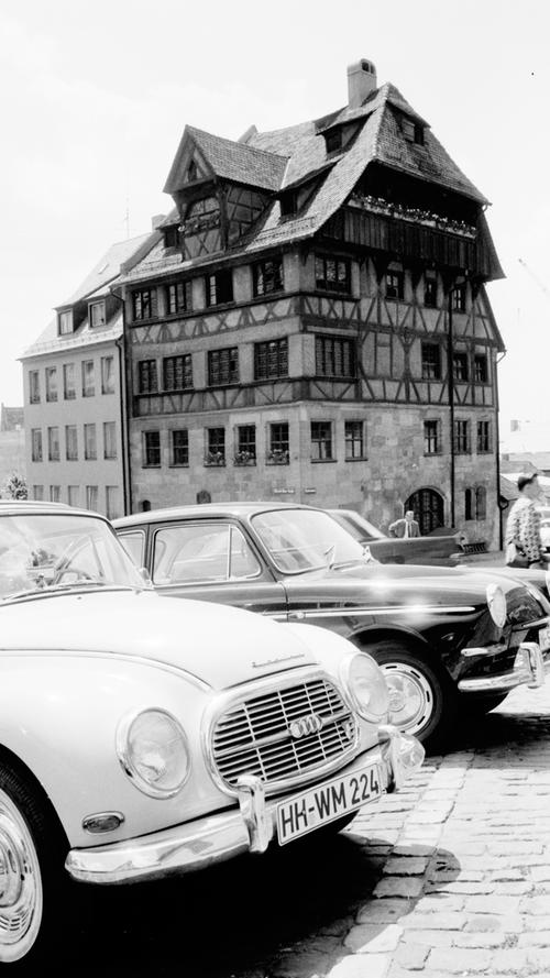 „Hummel-Hummel“ vorm Dürerhaus: auf dem Kopfsteinpflaster des historischen Platzes sammeln sich täglich viele „fremde“ Wagen.  Hier geht es zum Artikel: 12. Juli 1964: Urlaubswelle rollt über Nürnberg