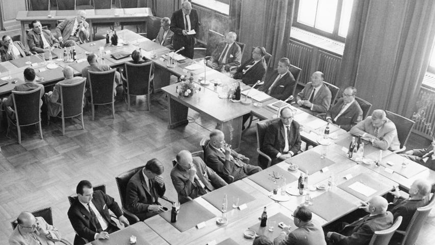 An einem großen "Hufeisen" sind die Stadträte zusammen mit Abgeordneten des Bundes und des Landes um den Minister geschart. Hier geht es zum Artikel: 19. Juli 1964: Die "Mitbringsel" des Ministers .
