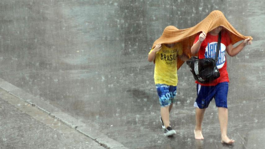 Donner und Regen: Franken verkriecht sich unter Schirmen