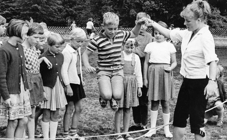 Bei der „Tageserholung“ auf der Spielwiese im Stadtpark ist allerhand los: gebannt verfolgen die Kinder das Seilspringen, wobei ihnen eine der freiwilligen Betreuerinnen hilft. Hier geht es zum Artikel: 9. August 1964: Frohe Kinder bei Spiel und Sport.