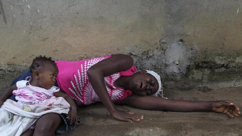 Eine Frau trauert im liberianischen Monrovia um einen Angehörigen, der an Ebola verstorben ist. Trotz zahlreicher Todesfälle warnen Experten aber vor Panik: Das HIV-Virus koste im Vergleich 1000 mal so viele Menschen jährlich das Leben.