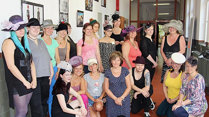 Die Schülerinnen der Modeschule und deren Lehrkärfte präsentieren die fertigen Einzelstücke - in der Mitte die "Hut-Meisterin" Nancy Paxton (ohne Hut).
