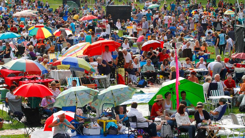 Unter bunten Schirmen suchten sich zahlreiche Besucher ein lauschiges Plätzchen im Luitpoldhain und lauschten den Klängen des Orchesters - dieses Mal glücklicherweise ganz ohne Wolkenbruch.