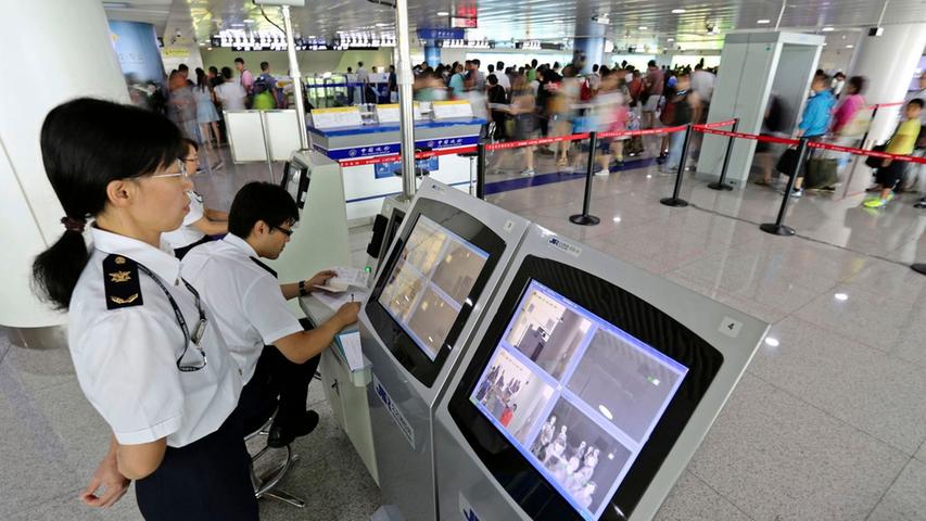 An Flughäfen herrscht höchste Sicherheitsstufe, wenn Flugzeuge aus betroffenen Gebieten landen. Die Sicherheitsbeamten scannen hier mit Hilfe der Monitore die Körpertemperatur der Passagiere.