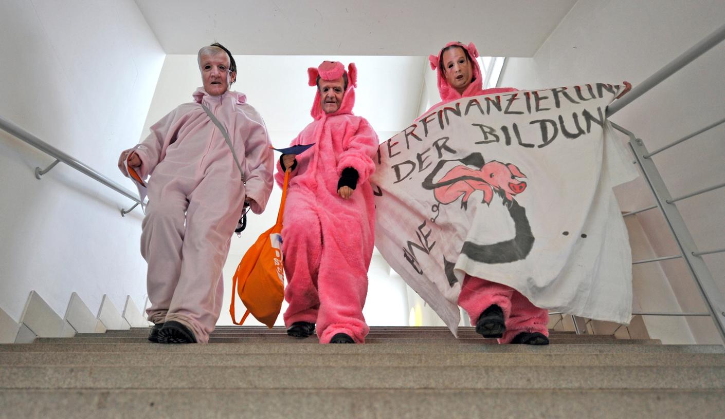 Kreative Studentenproteste an einer Münchner Fachhochschule: drei Studenten in Schweinchenkostüm und mit Masken von
bayerischen Politikern: "Big Pig" Horst Seehofer (CSU, links im Bild), "Humus Heubi" Wolfgang Heubisch (FDP, Mitte) und "Ferkelschon" Georg Fahrenschon (CSU, rechts im Bild) . Kreative Studentenproteste an einer Münchner Fachhochschule: drei Studenten in Schweinchenkostüm und mit Masken von
bayerischen Politikern: "Big Pig" Horst Seehofer (CSU, links im Bild), "Humus Heubi" Wolfgang Heubisch (FDP, Mitte) und "Ferkelschon" Georg Fahrenschon (CSU, rechts im Bild) .