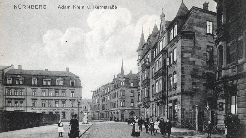 Bürger stehen im Jahr 1910 in der Nähe eines Kaufhauses in der Adam-Klein-Straße.