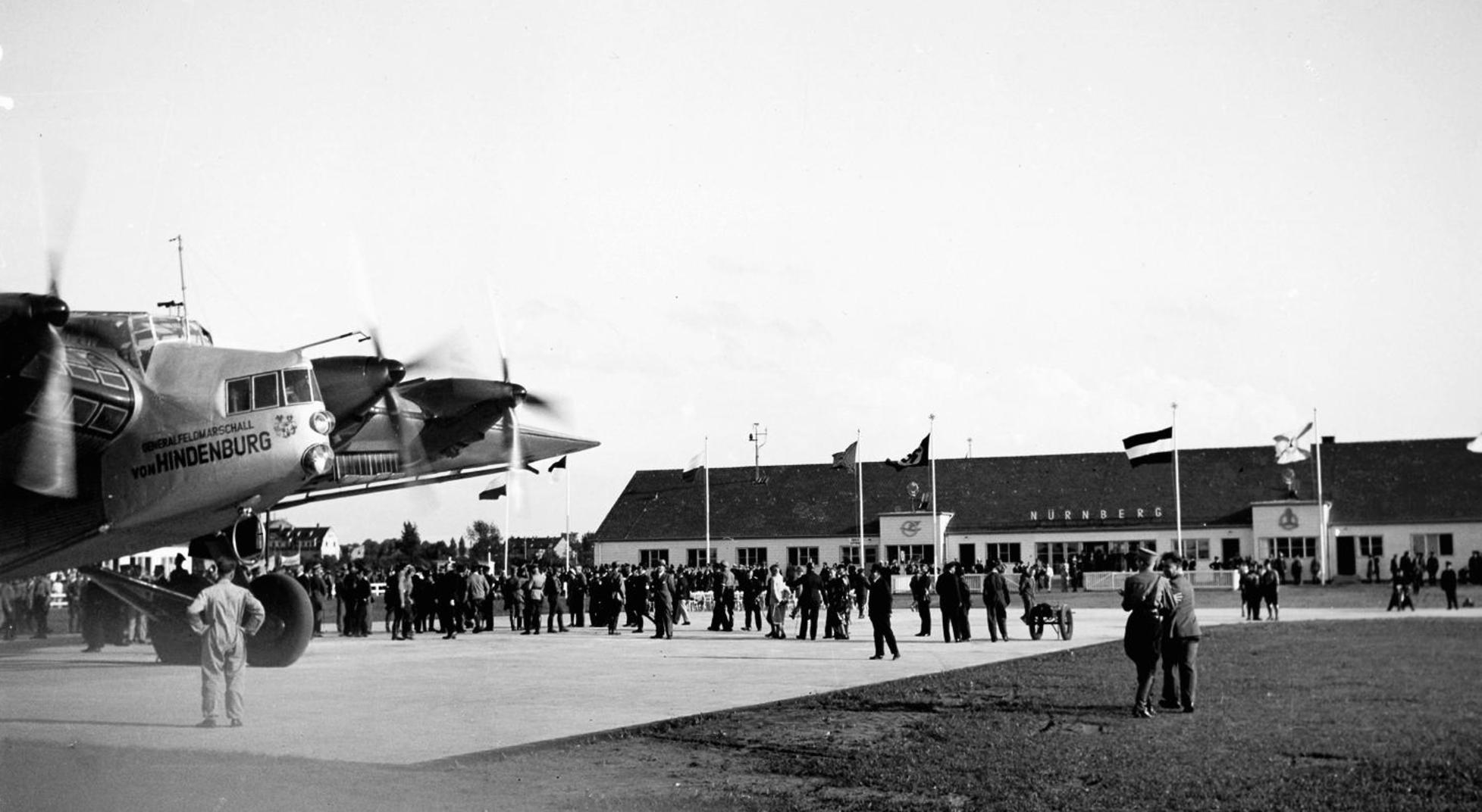 Streng genommen existierte noch ein weiteres Vorgängermodell, doch dieser Airport trug nicht umsonst den Namen "Nürnberg-Fürth", denn er lag in Fürth-Atzenhof. Im Volkspark Marienberg, wo heute Schrebergärten-Idylle herrscht und sich Hundebesitzer, Nordic-Walker und Jogger begegnen, entstand dann der erste Flughafen auf Nürnberger Stadtgebiet. Anlass für den damaligen Neubau war, dass die Atzenhofer Anlage schon längst an ihre Kapazitätsgrenzen gestoßen war. Ein Beschluss des Stadtrats von 1927 machte den Weg frei für den "eigenen" Flughafen, der im Stadtnorden zwischen Großreuth, Ziegelstein und Lohe entstehen sollte. Zum Einweihungstag des Flughafens im August 1933 wurde das zu dieser Zeit größte Flugzeug in Deutschland präsentiert, die "Generalfeldmarschall von Hindenburg".