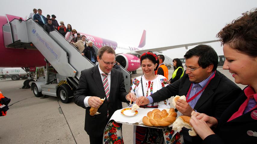 Airport-Chef Michael Hupe (vorne links) heißt am Mittwochfrüh zusammen mit Wizz Air-Sprecher Daniel de Carvalho (Zweiter von rechts) die ersten Passagiere aus Rumänien willkommen.