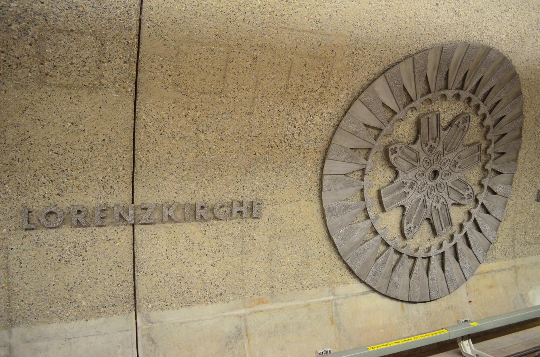 Wer mit der U-Bahn in die Innenstadt zur Haltestelle Lorenzkirche fährt, steigt direkt unter deren Fundament aus: In der Horizontalen gemessen beträgt der Abstand zwischen U-Bahntunnel und Fundament des Südturms nur rund einen Meter. Allerdings liegt die Tunnelröhre dreimal so tief wie die Unterkante des Fundaments. Damit das mittelalterliche Bauwerk nicht mit der Zeit im Boden versinkt, hat man beim Bau der U-Bahn sicherheitshalber Stahlbetonbohrpfähle eingetrieben – auch wenn das statisch nicht unbedingt nötig gewesen wäre. Die Rosette an der Tunnelwand des Bahnhofes repräsentiert übrigens die zehn Meter große Rosette in der Westfassade der Kirche.