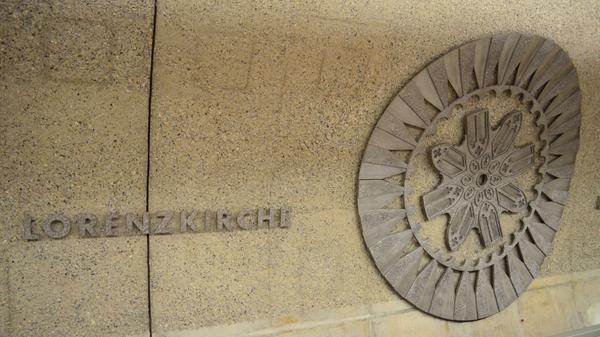 Wer mit der U-Bahn in die Innenstadt zur Haltestelle Lorenzkirche fährt, steigt direkt unter deren Fundament aus: In der Horizontalen gemessen beträgt der Abstand zwischen U-Bahntunnel und Fundament des Südturms nur rund einen Meter. Allerdings liegt die Tunnelröhre dreimal so tief wie die Unterkante des Fundaments. Damit das mittelalterliche Bauwerk nicht mit der Zeit im Boden versinkt, hat man beim Bau der U-Bahn sicherheitshalber Stahlbetonbohrpfähle eingetrieben – auch wenn das statisch nicht unbedingt nötig gewesen wäre. Die Rosette an der Tunnelwand des Bahnhofes repräsentiert übrigens die zehn Meter große Rosette in der Westfassade der Kirche.