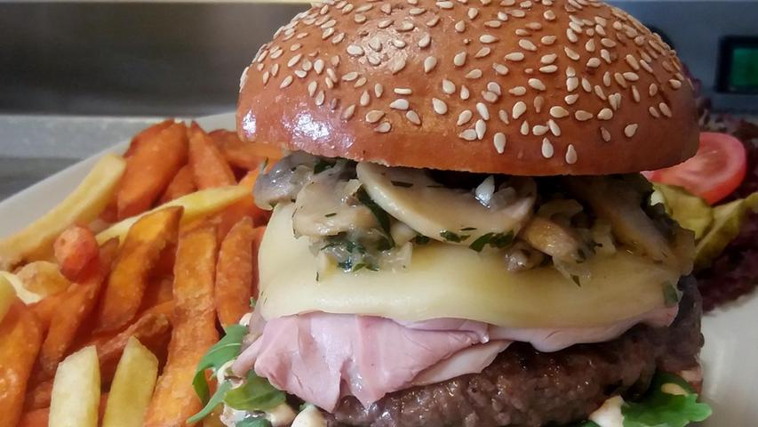 Beim Hoserer-Rolly’s werden Burgerfreunde glücklich, die von Masse und Klasse mehr halten als von Schein. Im einstigen Vereinsheim in Reichelsdorf gibt es neben soliden und gutgemachten Standard-Burgern auch abgefahrene Varianten wie die mit Erdnussbutter und Marmelade. Auf Wunsch werden allesamt auch mit Süßkartoffelpommes serviert. Besonders beachtlich sind die regelmäßigen und meist überbordend ausgestatteten Specialburger mit Chicken Wings, "Drunken Eggs" oder sogar Rippchen, die regelmäßig auf der Facebook-Seite verkündet werden. 356 Stimmen setzten das Hoserer auf Platz drei.
Mehr zum Hoserer gibt es in unserer Gastro-Datenbank. Beim Hoserer-Rolly’s werden Burgerfreunde glücklich, die von Masse und Klasse mehr halten als von Schein. Im einstigen Vereinsheim in Reichelsdorf gibt es neben soliden und gutgemachten Standard-Burgern auch abgefahrene Varianten wie die mit Erdnussbutter und Marmelade. Auf Wunsch werden allesamt auch mit Süßkartoffelpommes serviert. Besonders beachtlich sind die regelmäßigen und meist überbordend ausgestatteten Specialburger mit Chicken Wings, "Drunken Eggs" oder sogar Rippchen, die regelmäßig auf der Facebook-Seite verkündet werden. 356 Stimmen setzten das Hoserer auf Platz drei.
Mehr zum Hoserer gibt es in unserer Gastro-Datenbank.