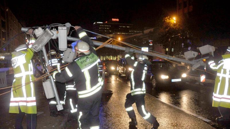Feuerwehrkräfte sicherten in Stuttgart in der Innenstadt eine Ampelanlage, die bei einem Sturm von durch die Luft geschleuderten Gegenständen einer nahliegenden Baustelle beschädigt wurde.