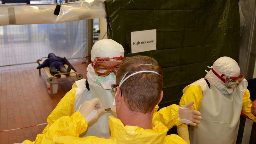 Die Mediziner halfen sich gegenseitig beim Anziehen der Schutzkleidung. In einem Ebola-Krankenhaus kann schon der kleinste Fehler zur Infizierung führen.