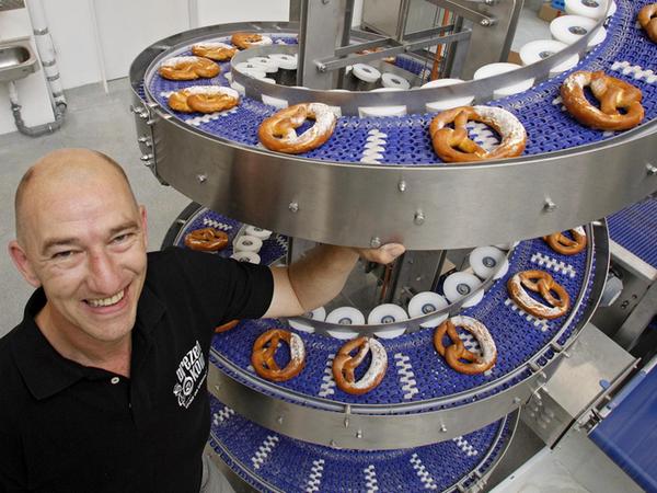 Letzte Fahrt: Oliver Seiche kümmert sich als Bäckermeister um die Produktion der Brezen. Ist das Laugengebäck fertig, wandert es über eine Spirale in den Verkauf.