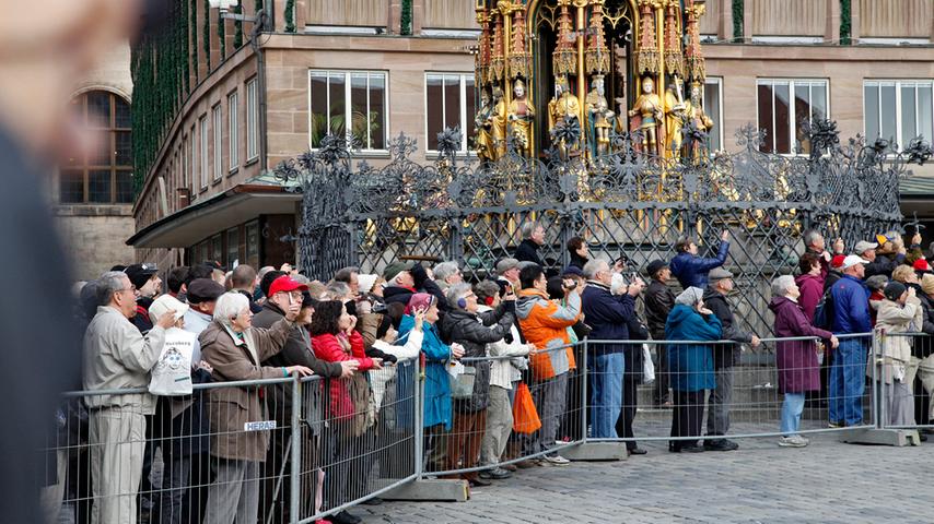 Die Touristen, die derzeit zur Mittagszeit das Männleinlaufen an der Frauenkirche beobachten wollen, drängen sich wie Zaungäste an den Absperrungen.