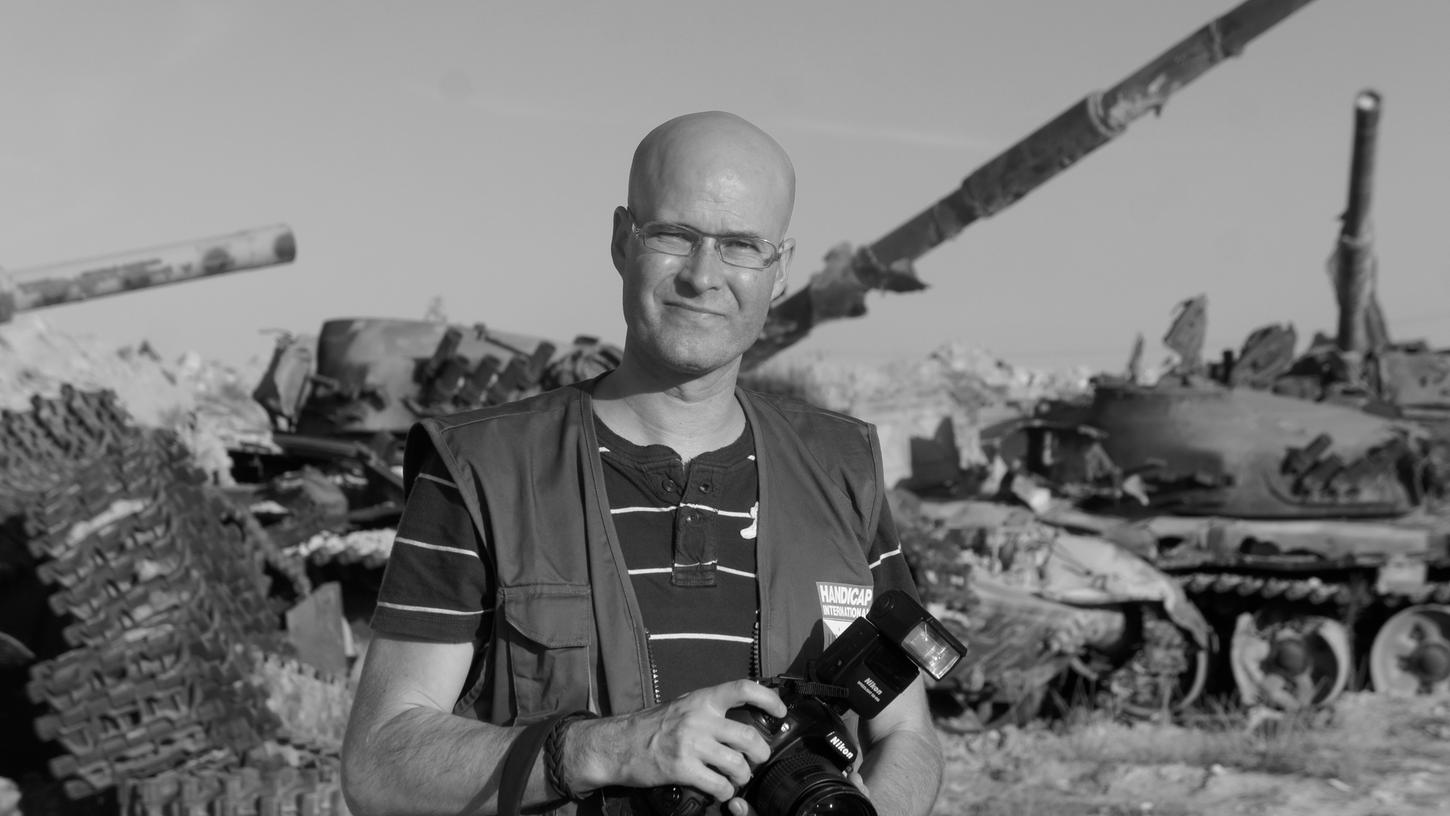 Till Mayer berichtet als Journalist und Fotograf aus Kriegs- und Krisengebieten. Hier steht er vor Panzern in Libyen.