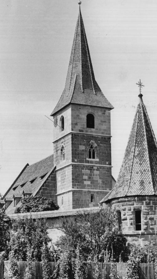 Das Wahrzeichen des Knoblauchslandes von Südosten aufgenommen: Im Vordergrund die in die Wehrmauer eingebaute Gruftkapelle, innerhalb der Befestigung die Kirche mit ihrer neuen Turmspitze.