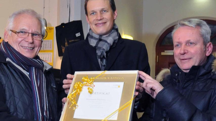 „Du bist Gold wert“: OB Matthias Thürauf und Bruno Fetzer (rechts) bedankten sich mit dem ersten neuen Goldrahmen bei Rudi Nobis (links).