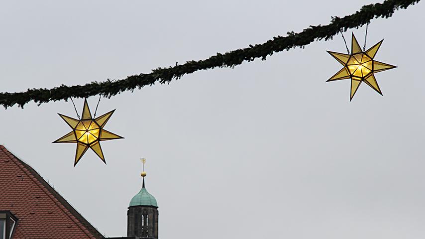 Der Himmel ist grau, aber immerhin ist es trocken. In der Nürnberger Altstadt wird mit weihnachtlicher Beleuchtung auf den Christkindlesmarkt eingeladen.