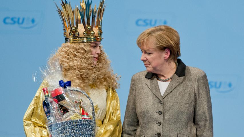 Das Nürnberger Christkind, Teresa Treuheit (l), übergibt der Bundeskanzlerin  Angela Merkel (CDU) am 12.12.2014 in Nürnberg (Bayern) während des  CSU-Parteitages einen Geschenkkorb. Vom 12.-13.12.2014 findet in Nürnberg der  CSU-Parteitag statt. Foto: Daniel Karmann/dpa +++(c) dpa - Bildfunk+++