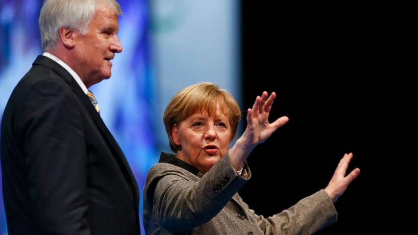 Angela Merkel, German chancellor and leader of the Christian Democratic Union  party CDU, and Horst Seehofer, federal Bavarian state premier and leader of  Bavaria's Christian Social Union party CSU, acknowledge applause from the  delegates of the CSU party congress in Nuremberg December 12, 2014.  REUTERS/Michael Dalder (GERMANY - Tags: POLITICS)