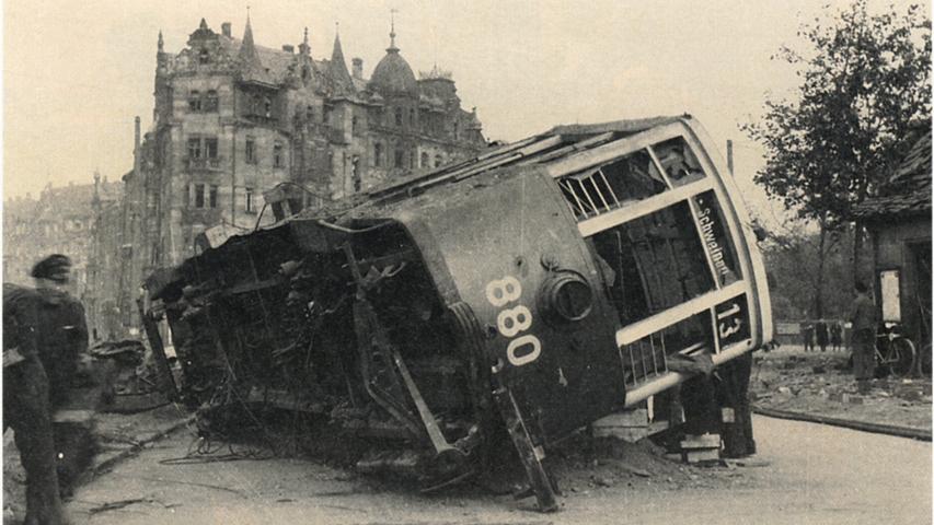 Während des Zweiten Weltkriegs trafen den Plärrer etliche Fliegerbomben. Ein Wagen der Linie 13 wurde bei einem Luftangriff am Plärrer aus den Schienen geschleudert. Im Hintergrund ist das Hansahaus zu sehen, das bis heute ein Aushängeschild am Plärrer ist. 
