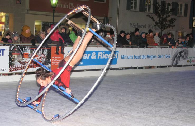 Akrobaten mit Röhnrad und Schlittschuhen auf dem Eis