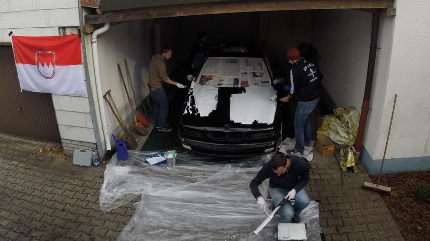Alte Farbe runter, neue drauf - Simon, Alex (ein Bekannter des Teams), Max und Philipp beim Umlackieren in der Garage.