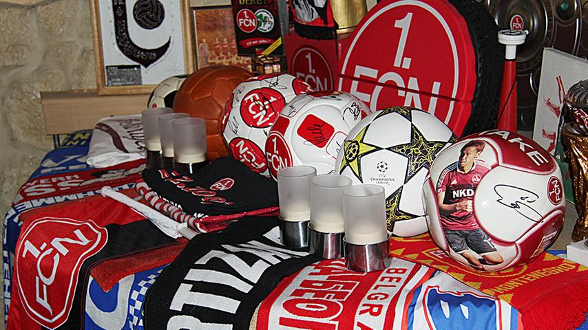 Verschiedene Fußbälle, Schals und Pokale: Der Fan-Altar widmet sich nicht nur dem Club - doch während des Club-Spiels schlagen alle Fanherzen im Takt.