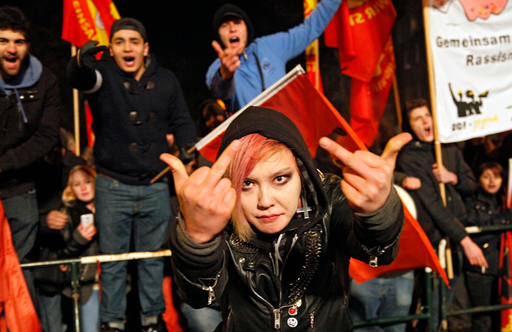 Eine antifaschistische Gegendemonstrantin zeigt den N&uuml;gida-Demonstranten gleich zwei Stinkefinger.