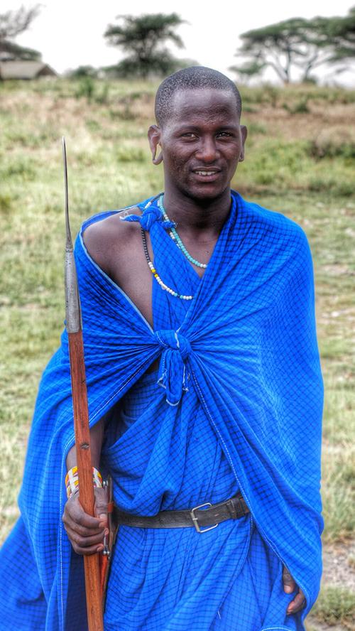 Ein Masai-Krieger begleitet die Gäste im Camp mit seinem Speer.