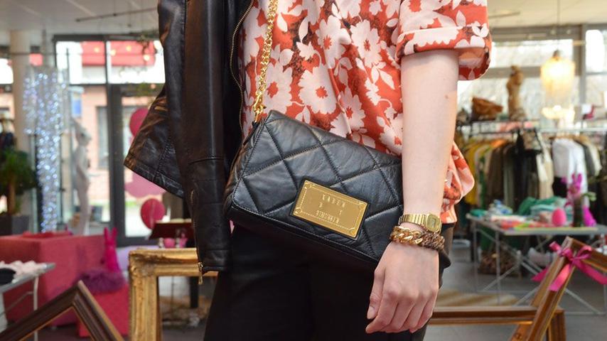 Als praktischen Begleiter bekommt Viola eine schwarze Tasche im Stil des französischen Modehauses Chanel. Ein großes Statement-Armband und eine Uhr komplettieren den Look.