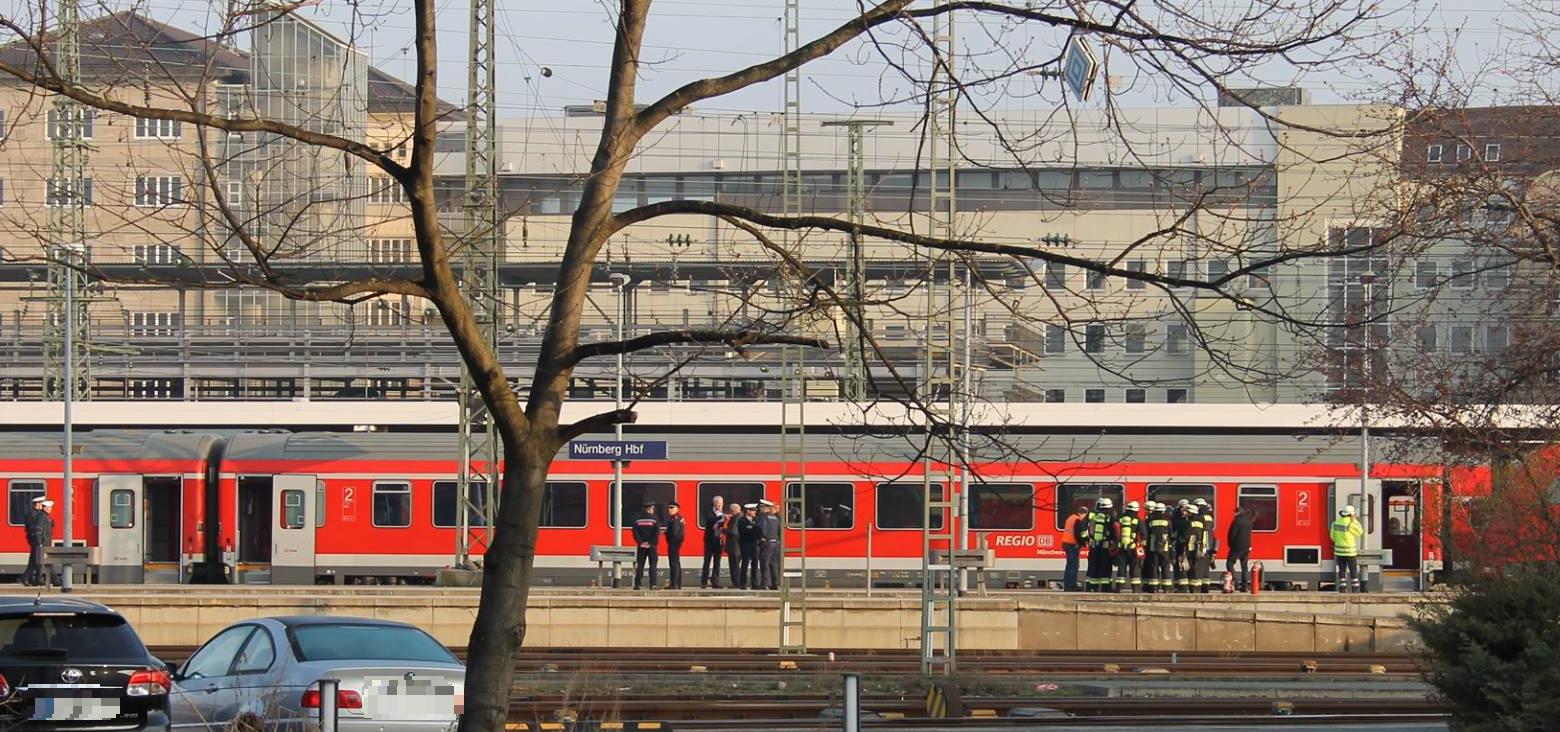 Einsatzkräfte machen sich ein Bild von dem Zug, an dem sich der Stromüberschlag ereignet hat.