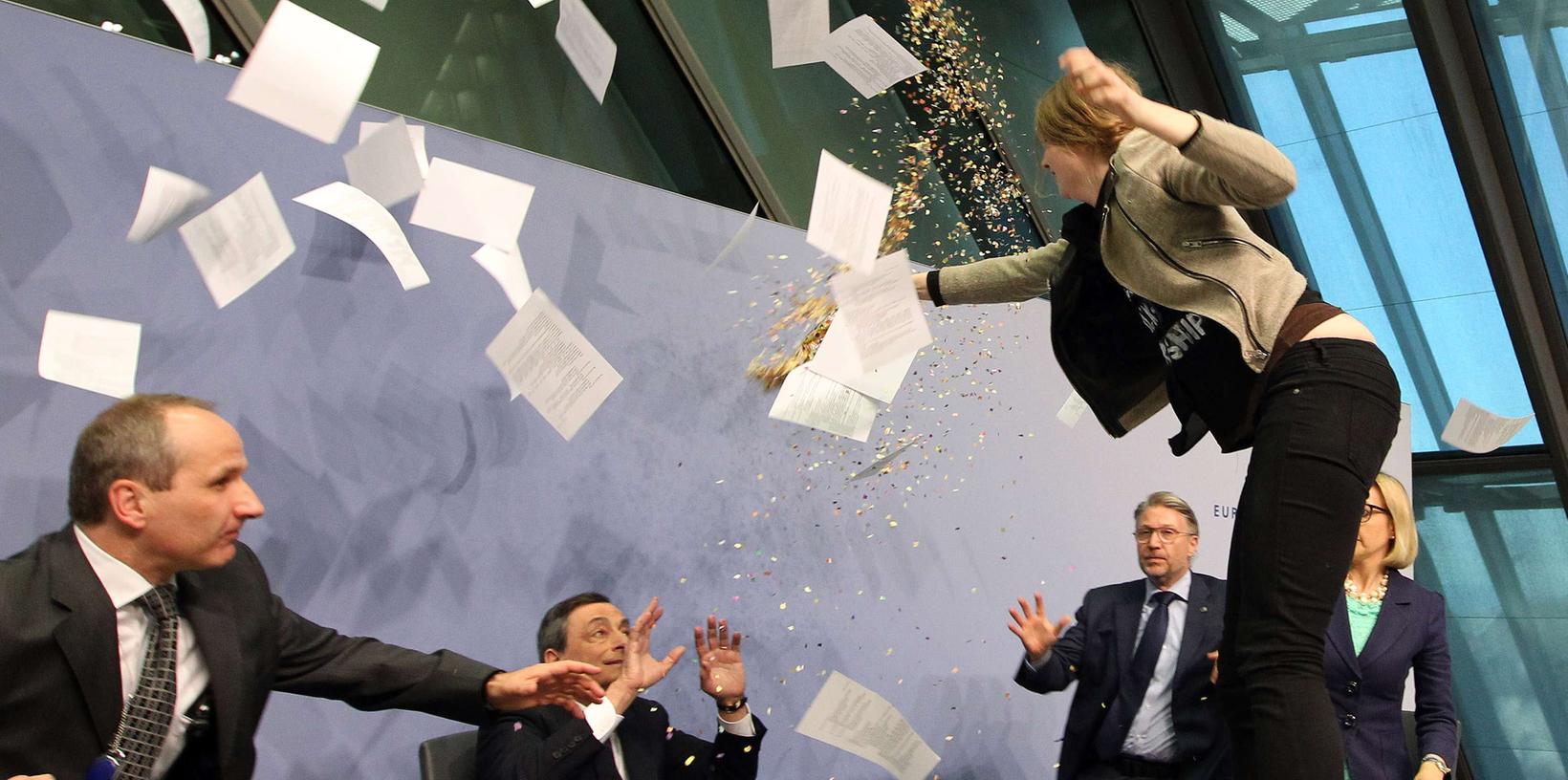 Ein erschreckender Moment für EZB-Chef Mario Draghi: Eine Frau sprang bei einem Pressegespräch auf das Rednerpult.