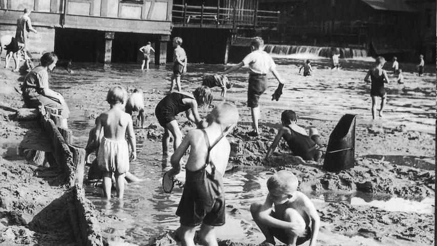 Dieses Bild stammt wohl aus den 1920-er Jahren und zeigt das Flussbad an der Pegnitz auf Höhe der Dürrenhofmühle in Nürnberg. Nürnberger Kinder spielen im damals hippen "Läbberie" unterhalb der Nägleinsmühle. Die schon größeren Jungen durchwaten den Fluß unterhalb des Wehres bei der Dürrenmühle.