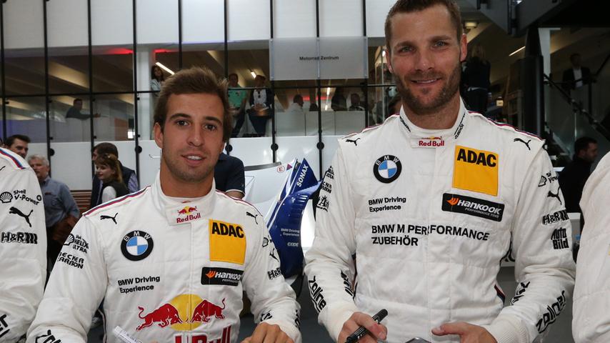 Auch Antonio Felix da Costa (BMW-Team Schnitzer, links) und Martin Tomczyk (BMW-Team Schnitzer, rechts) unterschreiben fleißig ihre Autogrammkarten.