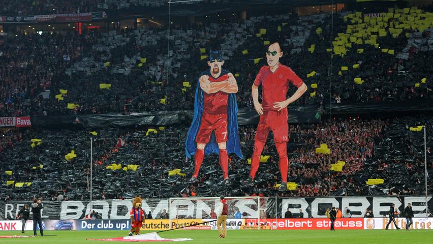 "The real Badman & Robben": Die Fans des FC Bayern nehmen in ihrer Choreographie Bezug auf die Dortmunder Aubameyang und Reus, die vor Wochen ein Tor mit entsprechenden Masken zelebiert haben.