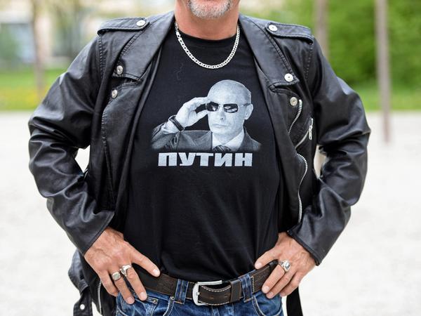 Ein Sympathisant des russischen Motorradclubs "Nachtwölfe" trägt am 04.05.2015 vor dem Eingang zum ehemaligen Konzentrationslager in Dachau (Bayern) ein T-Shirt mit einem Porträt des russischen Präsidenten Putin.