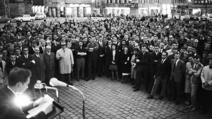 Vor 1.000 Kommilitonen, die mit Protestrufen nicht sparten, sprachen gestern Abend Studentenvertreter zur Standortfrage der Fakultät. Hier geht es zum Artikel vom 26. Mai 1965: 1000 Stimmen am Hauptmarkt.