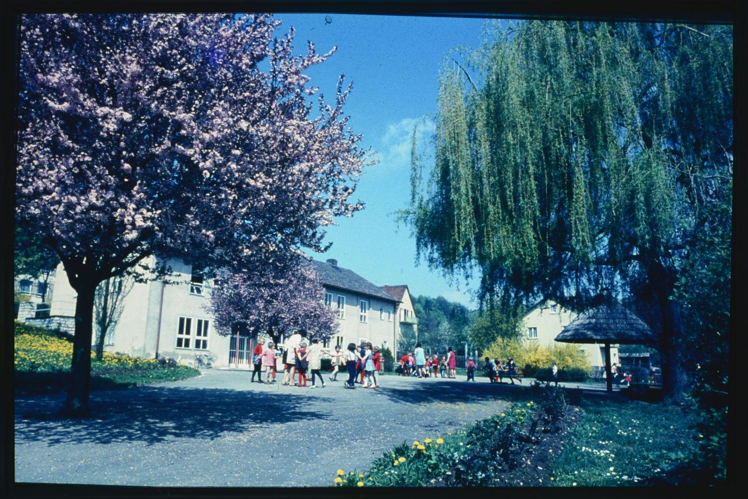 Ein der Redaktion zunächst unbekanntes Schulgebäude. Wie unsere Leser Alexander Kuhr und Kathrin Ronneberger mitteilten, handelt es sich um den städtischen Kindergarten, wie er einst aussah. Das Foto wurde von der Hahnenkammstraße aus aufgenommen. Im Hintergrund sind die Fenster der Grundschule zu sehen.
