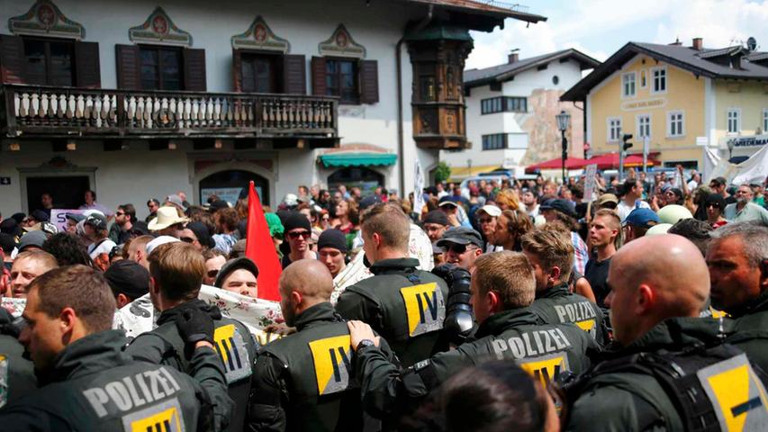 Im Tal ist die Stimmung aufgeheizt. Etwa 600 Protestler versammeln sich bei über 30 Grad im Schatten in Garmisch-Partenkirchen zu einer Kundgebung - immer unter den Augen der Bereitschaftspolizei.