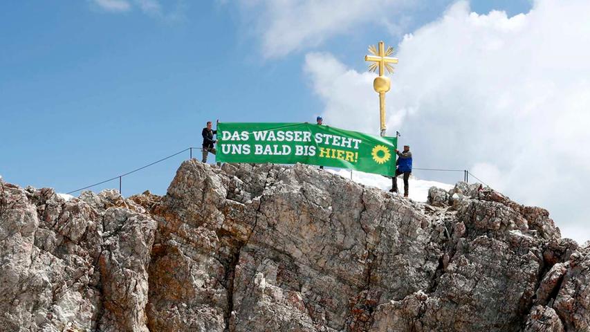 Die Grünen entrollen derweil ein symbolträchtiges Banner auf dem Gipfel der Zugspitze, Deutschlands höchstem Berg (2962 Meter).