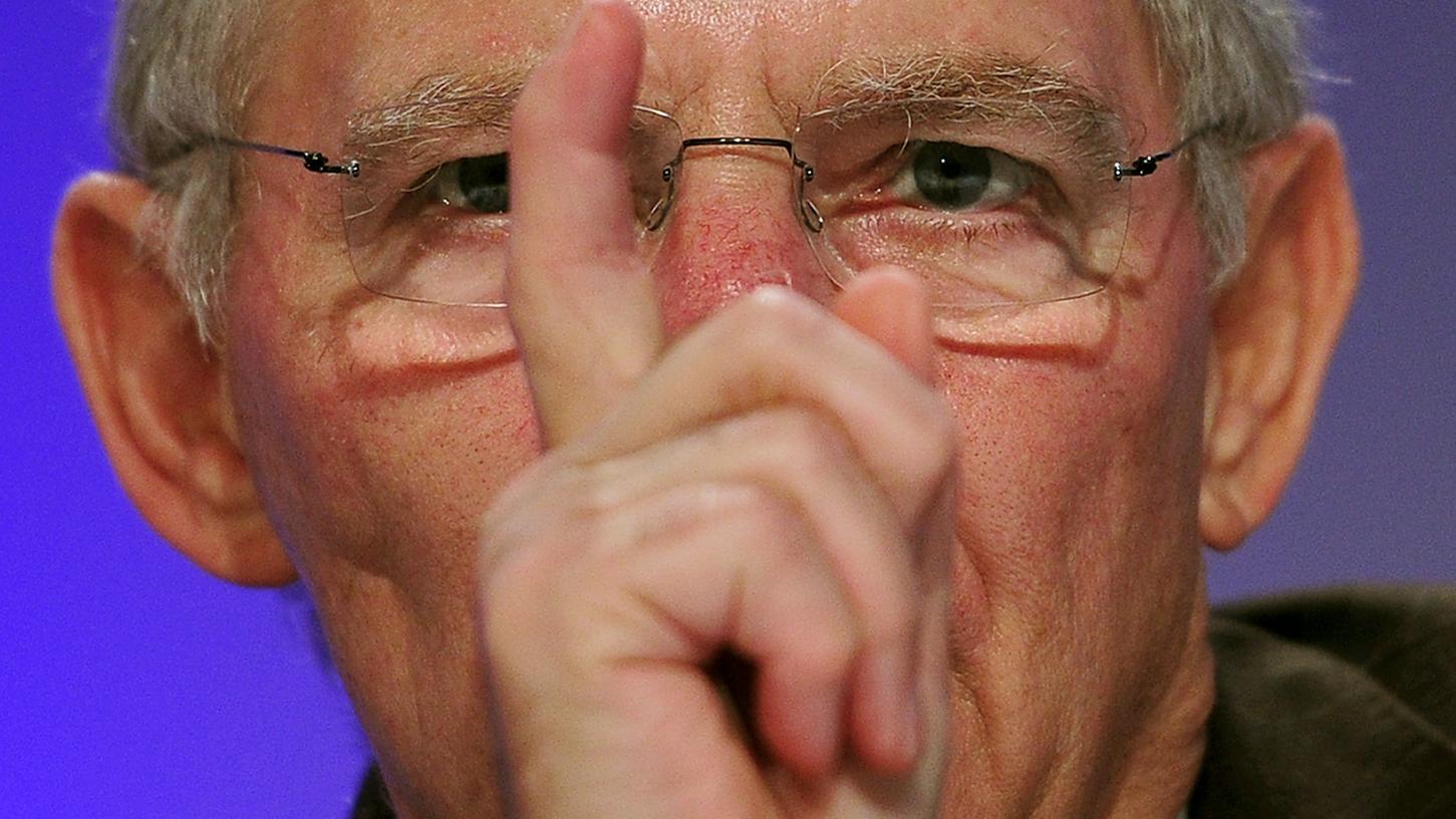 Finanzminister Schäuble zeigt mit dem Finger auf die VW-Manager, die in der Krise nicht auf Boni verzichten wollen.