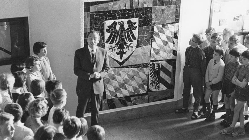 Oberstudiendirektor Dr. Karl Lanig präsentiert das Mosaik.  Hier geht es zum Artikel vom 17. Juni 1965: Symbole aus farbigen Steinen.