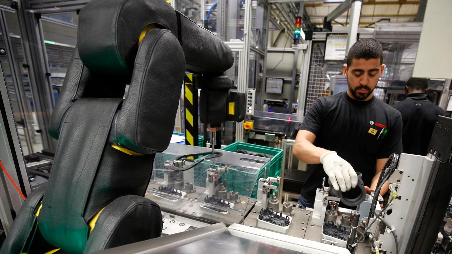 Es muss kein Gegeneinander sein: Bei Bosch arbeiten Roboter und Mensch Hand in Hand.