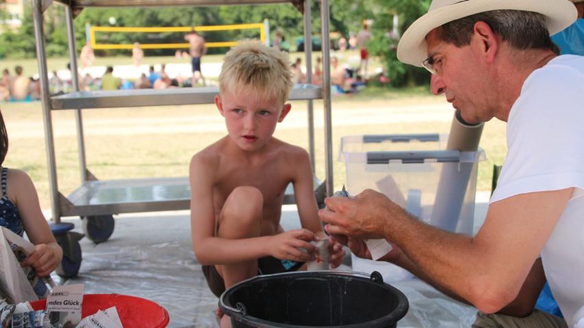Andreas Neundoerffer zeigt einem kleinen Jungen, wie man einen Sumurai aus Pappmaché herstellt.