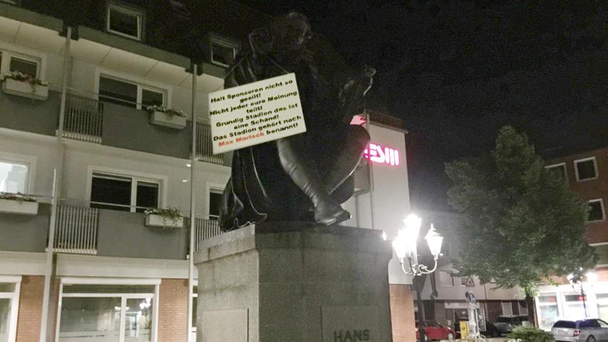 Auf dem Hans-Sachs-Denkmal prangte ein Schild, auf dem stand: "Halt Sponsoren nicht so geeilt! Nicht jeder eure Meinung teilt! Grundig Stadion das ist eine Schand! Das Stadion gehört nach Max Morlock benannt!"