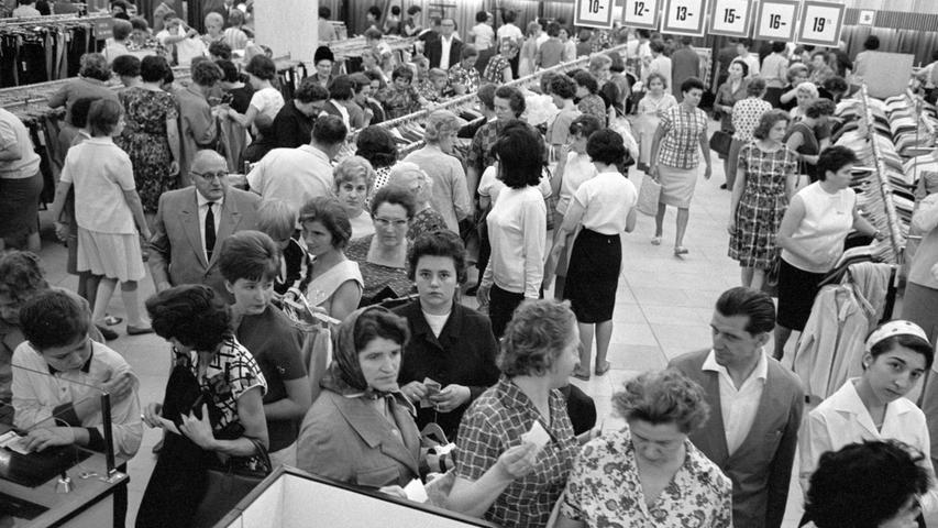 'Stoßbetrieb' in den Kaufhäusern: mal herrschte gedrängte Enge vor, mal gab es an Theken und Ständern wieder 'Luft'. Hier stehen die Kunden an der Kasse Schlange. Gleich rollt der Rubel."  Hier geht es zum Artikel vom 27. Juli 1965: "Bonbons" sehr gefragt.