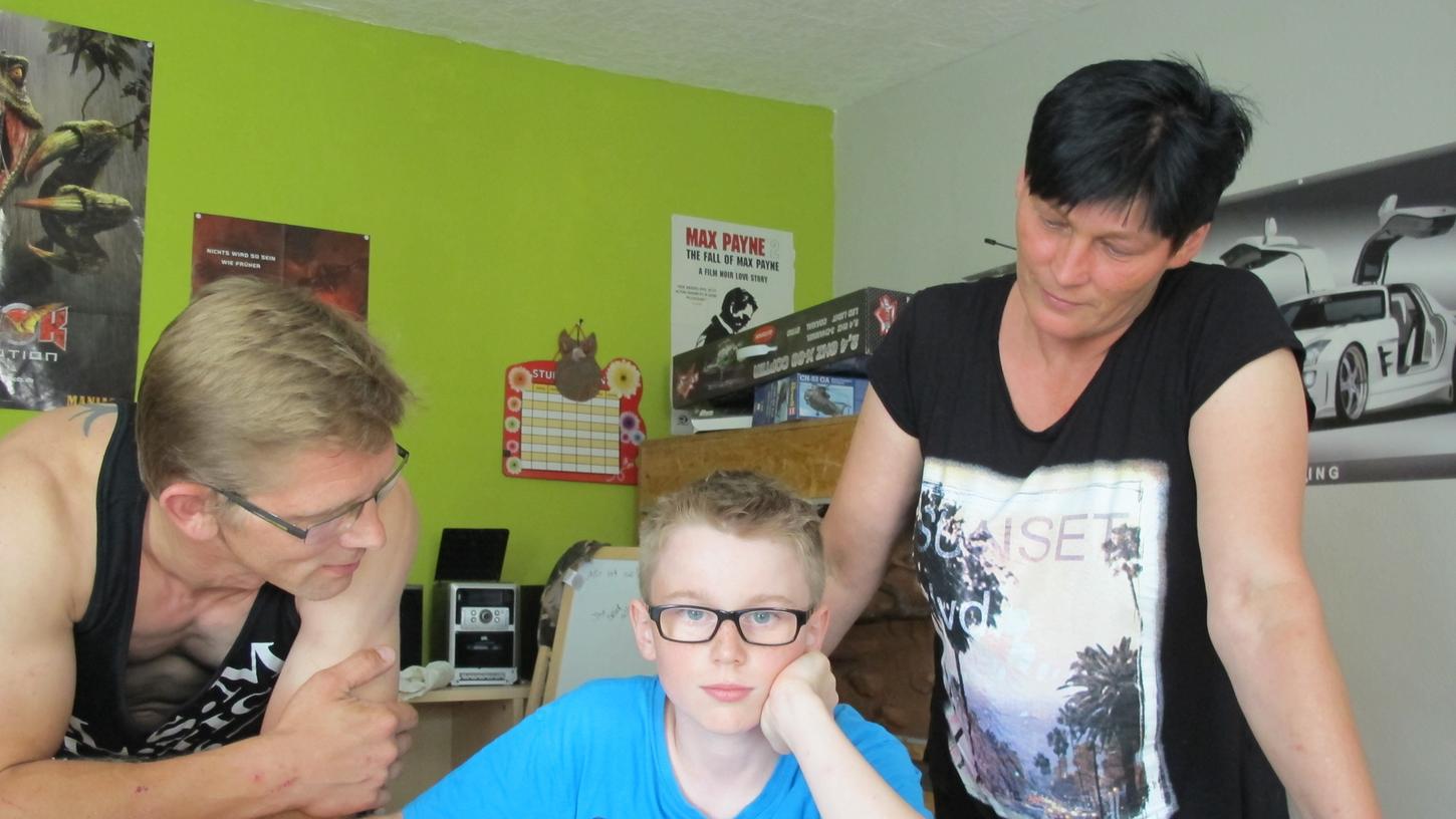 Haben die notwendige Schul-Zuweisung erhalten: Schüler Franz (m.) und seine Eltern. Haben die notwendige Schul-Zuweisung erhalten: Schüler Franz (m.) und seine Eltern.